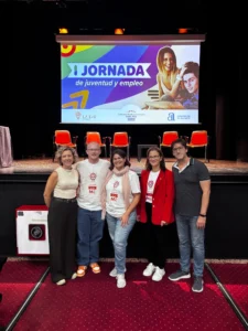 Ponentes y organizadores de la I Jornada de Juventud y Empleo en Santa Pola posando frente al cartel del evento