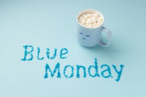 aza de café con malvaviscos sobre fondo azul con la frase "Blue Monday".