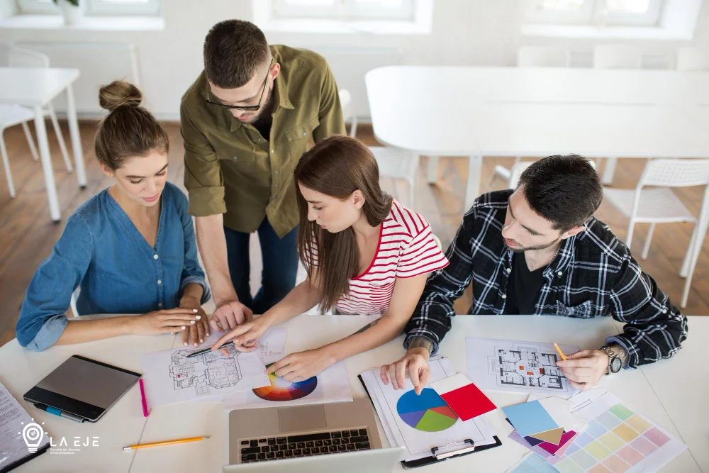 Grupo de jóvenes trabajando en equipo en un proyecto de diseño en un entorno profesional.