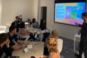 taller formativo de La EJE donde un ponente presenta contenidos sobre emprendimiento y tecnología a un grupo de jóvenes emprendedores en aula.